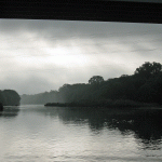 River and sky made grey by dark clouds overhead.