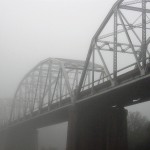 A bridge shrouded in early-morning mist.
